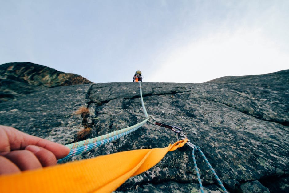 Capture the thrill of rock climbing with this dynamic low-angle shot showcasing determination and teamwork.
